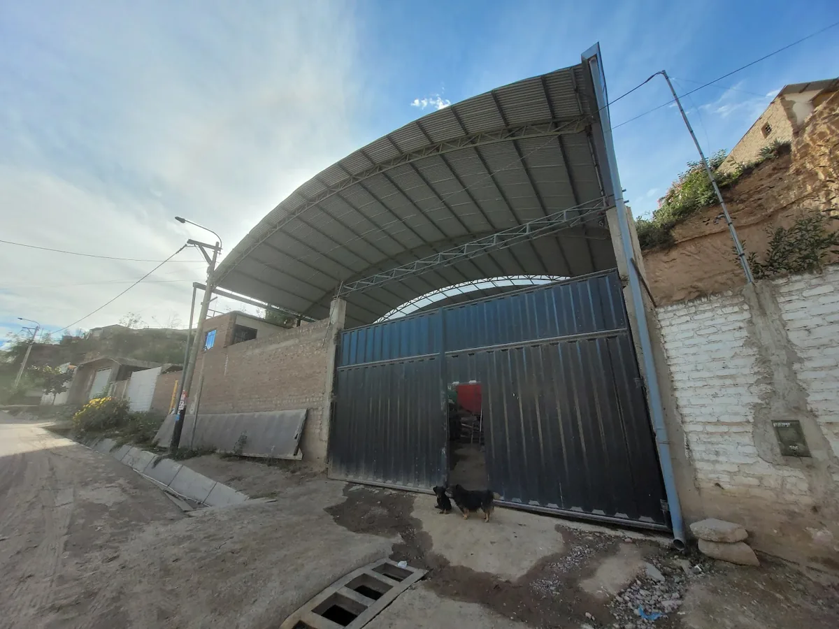 Fachada real del taller FAMELE en Ayacucho, con portón metálico y cobertura de acero